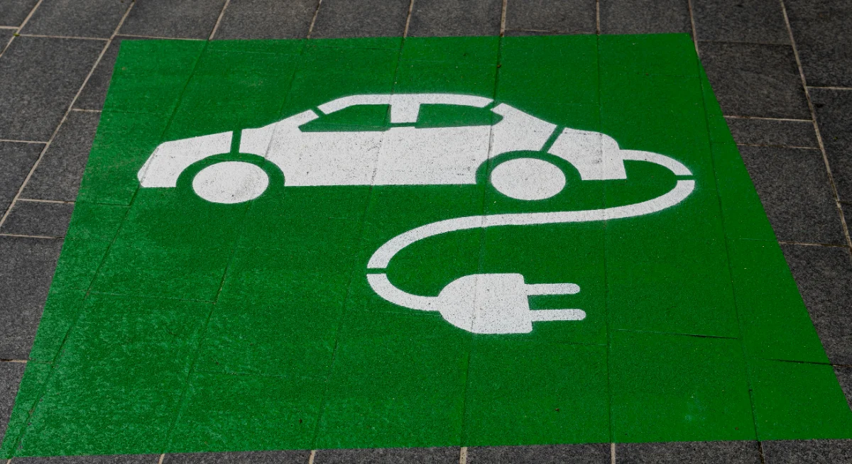Cargador conectado a un vehículo eléctrico en un parqueadero